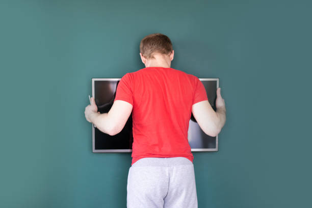 repair and decoration. 'husband for an hour' service. man hangs tv on the wall.